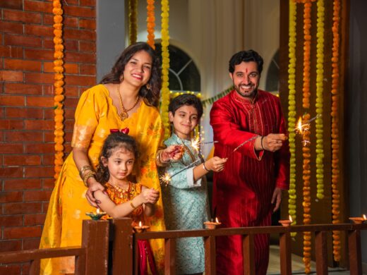 Indian family of four celebrating Diwali with sparklers, creating festive memories together