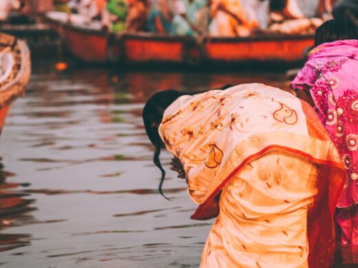 people perform ritual puja at dawn in the Ganges River in Varanasi, India