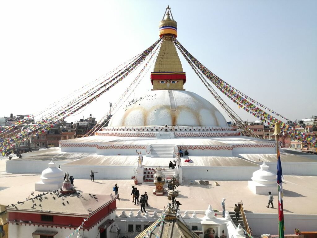 Spherical Boudhanath with white walls and decorative flags strained from spire located in Kathmandu Nepal