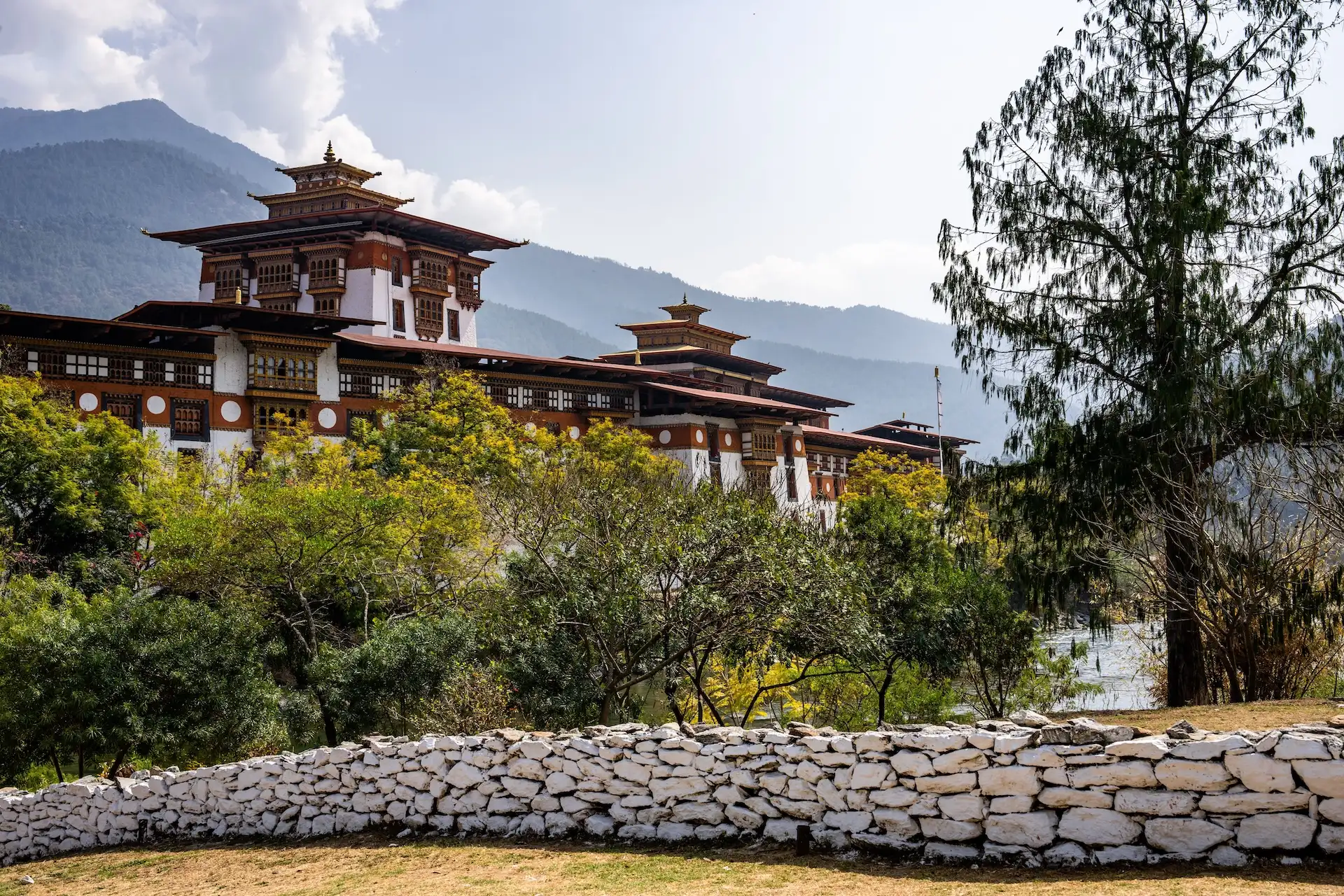 The Punakha Dzong Fortress with prayer wheels, surrounded by greenery
